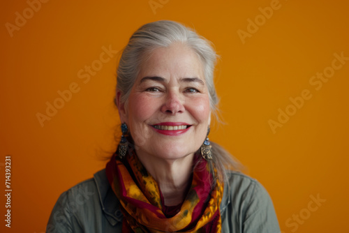 A woman wearing a scarf and earrings smiles for the camera