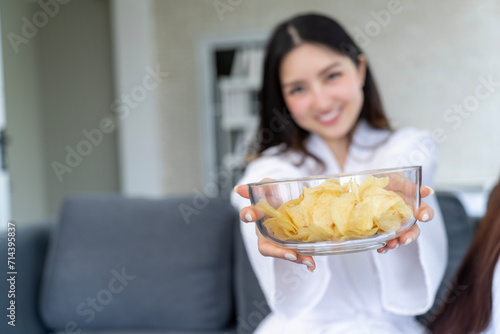 Stylish Bedroom Party  Young Woman in White Bathrobe Presents Glass Bowl of Potatoes
