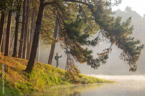Canvastavla Traveller is trekking through the misty mountain with pine forest by lake view d