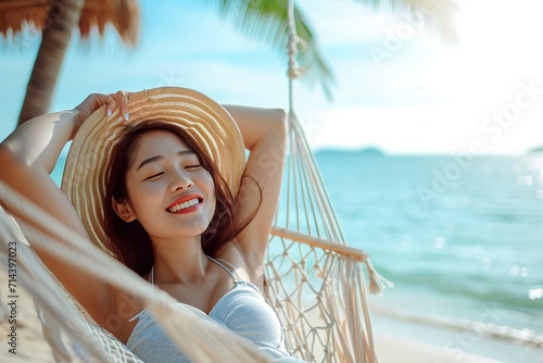asian woman relax on hammock in the beach photo