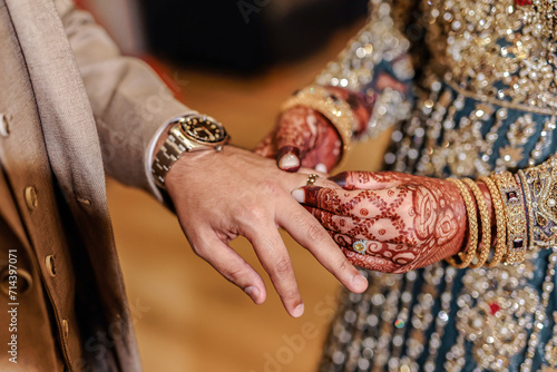 Indian couple's exchanging rings hands close up