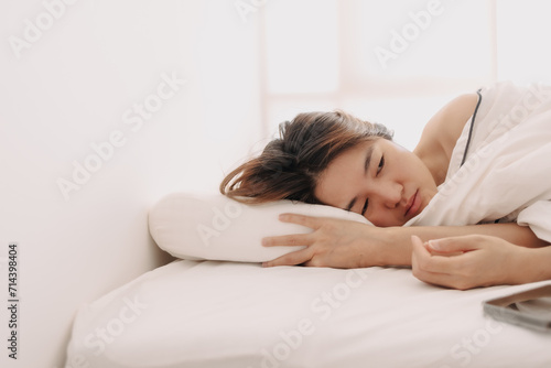 Sad and depressed Asian woman lie awake in the morning to weak to get up form bed.