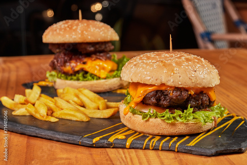 Delicious burger with double meat, caramelized onion, fresh vegetables and potatoes
