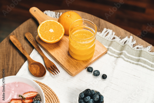 Presenting special drink of fresh orange juice serve with yogurt toppings with berry fruit placing on wood serving decorated. Set of healthy choice at breakfast time for nutrition benefit. Pecuniary.