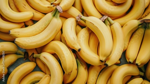  a pile of ripe bananas sitting on top of each other on top of a blue tablecloth covered tablecloth in front of a pile of yellow and green bananas. photo