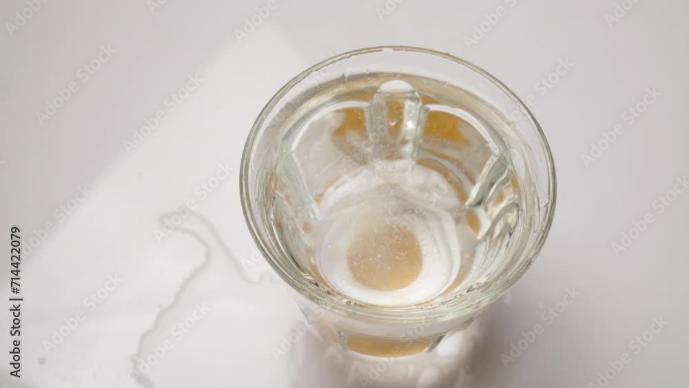 Soluble aspirin tablet in a glass of water on a white table top view Soluble aspirin tablet in a glass of water on a white table top view