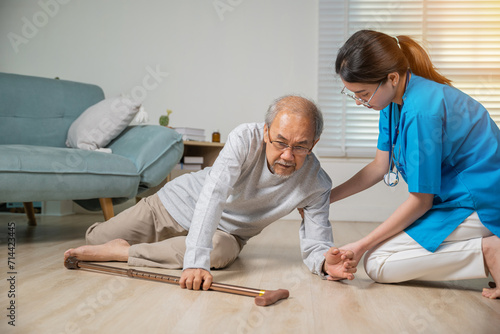 Disabled elderly old man patient with walking stick fall on floor and caring young assistant at nursing home, Asian older senior man falling down on lying floor and woman nurse came to help support