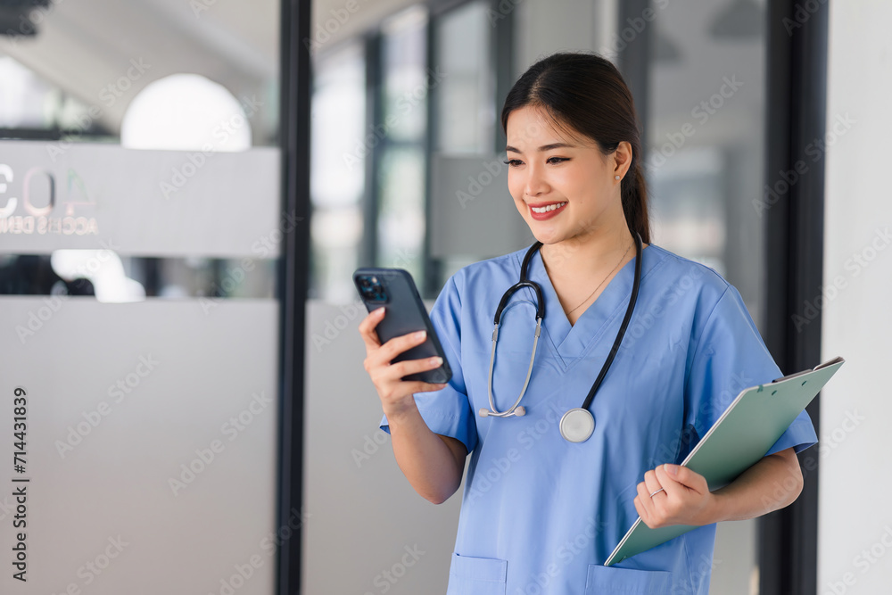 Asian Nurse with Smartphone and Clipboard on Hospital Shift. Asian Nurse with Smartphone and Clipboard on Hospital Shift.