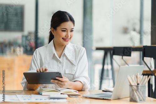фотографія Professional Woman Analyzing Data on Tablet at Desk.