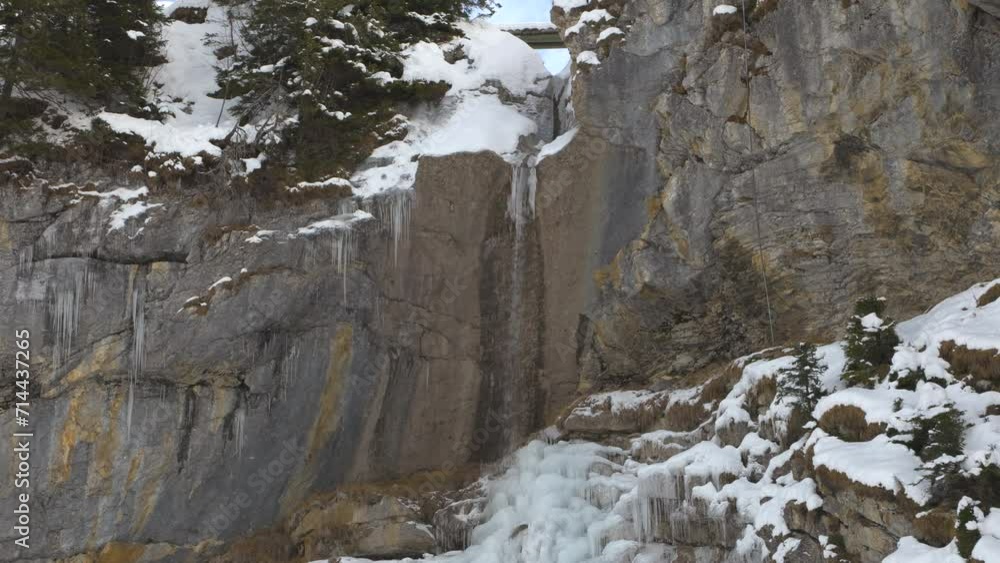 Freezing waterfall in snowy mountains. Crystal clear icicles frozen at snowy waterfall. Freezing waterfall in snowy mountains. Crystal clear icicles frozen at snowy waterfall.