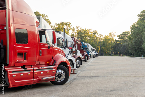 Row of Colorful Semi Trucks Parked at a Rest Area at Dusk photo