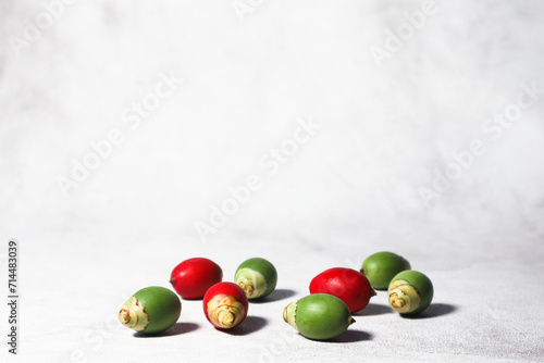 Green and red palm fruits (buah palem). Green color on white and gray backgrounds. photo
