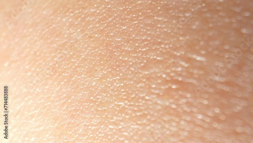 In macro footage, arm skin reveals a mesmerizing landscape of tiny pores, fine hairs, and subtle textures, resembling a miniature world. 4K.
 photo