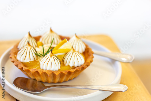 Lemon Tart in white plate on wooden table with copy space.