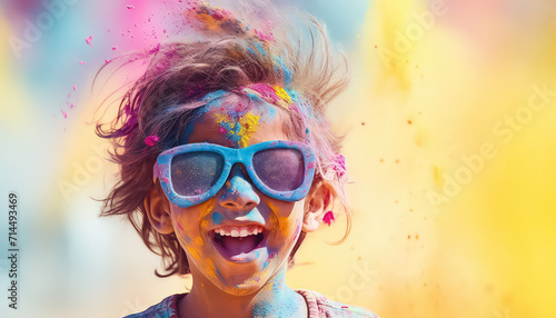 Happy kid in glasses and paint dust at festival   happy holi indian concept