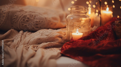 A warm and cozy setting featuring soft textiles and a lit candle, creating a peaceful and relaxing ambiance.