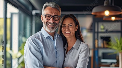 Envision a man and a woman, both in their forties, standing at the culmination of a fruitful negotiation. Their smiles radiate genuine happiness, embodying the satisfaction of a successful deal.   © chaynam