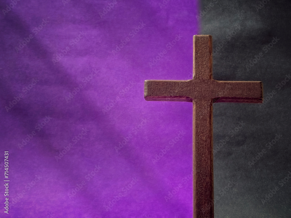 Lent Season, Holy Week, Good Friday, Easter Sunday Concept. Close up of wooden cross with purple and black colours background. For copy space.