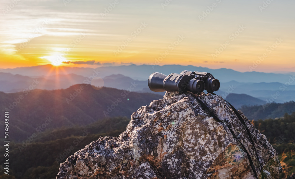 binoculars on top of rock mountain at beautiful sunset background. - obrazy, fototapety, plakaty 