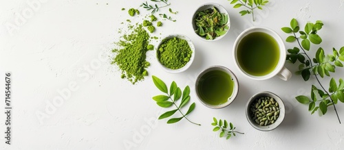 Moringa tea arranged creatively on a white surface in a flat lay style, showcasing food and macro concepts. photo
