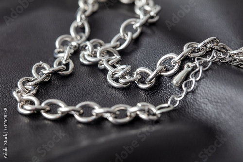 Silver chain on a black leather background