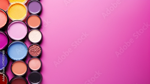 colorful frame with various makeup products on pink background with copy space