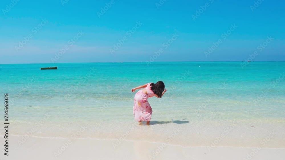 Indian girl splashing water of sea waves at beach. Girl enjoying sunny summer day at white sand beach of Lakshadweep, India. Summer holidays concept. Tourist enjoying vacation at tropical island. Indian girl splashing water of sea waves at beach. Girl enjoying sunny summer day at white sand beach of Lakshadweep, India. Summer holidays concept. Tourist enjoying vacation at tropical island.
