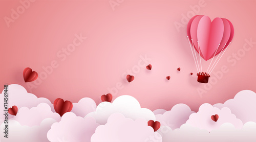 Paper cut art and digital craft style of love and valentine concept. Origami of hot air balloon flying over sky and cloud with floating hearts.