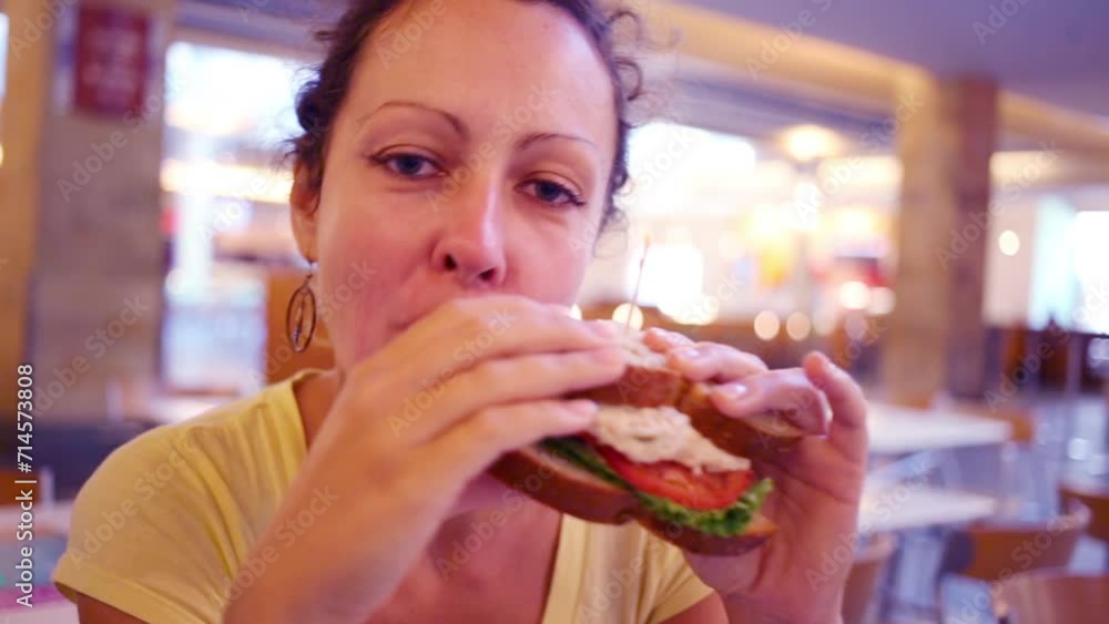 Happy woman eats fresh delicious sandwich in bakery Happy woman eats fresh delicious sandwich in bakery