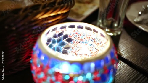 Female hand touches by fingers bowl made of glass with candle. photo