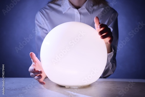 Photography Businesswoman using glowing crystal ball to predict future at table, closeup