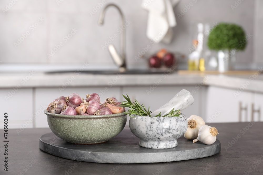 Fresh raw garlic and rosemary on grey table Fresh raw garlic and rosemary on grey table