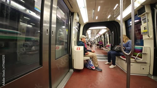 Children sit on seats of fast moving subway train car. photo