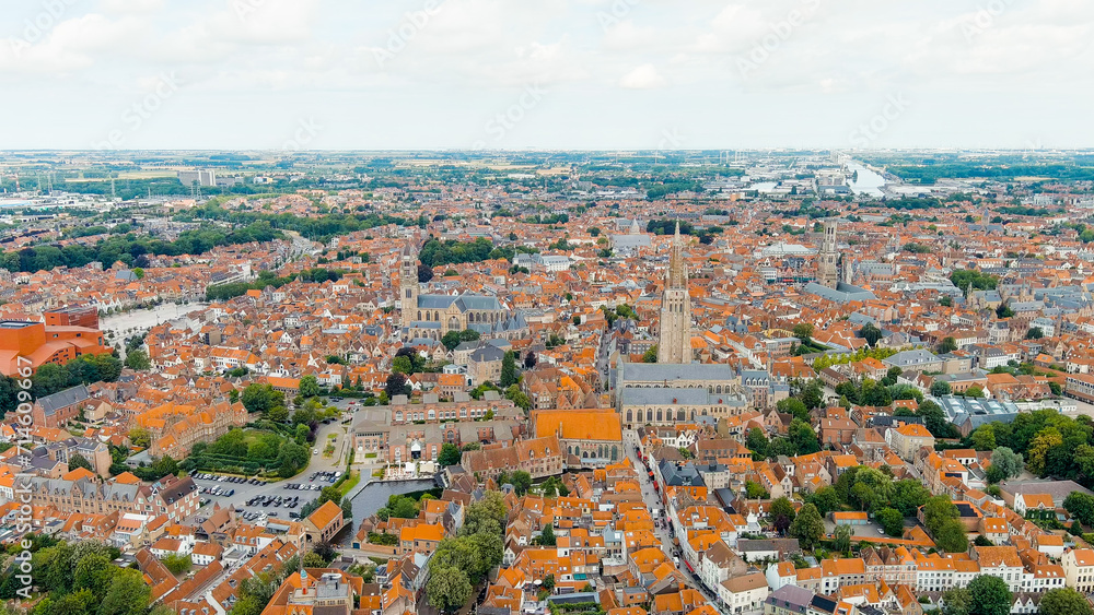 Bruges, Belgium. Church of Our Lady - Gothic church from the 13th century. Panorama of the city center from the air. Cloudy weather, summer day, Aerial View