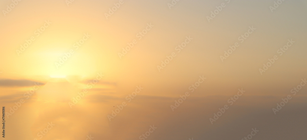 Blurry yellow light soft panorama sunset sky background with light yellow clouds