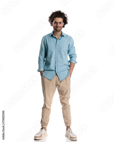 casual man wearing blue shirt with hands in pockets