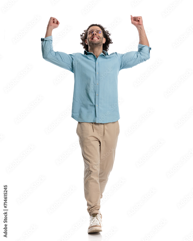 celebrating casual man with hands in the air looking up celebrating casual man with hands in the air looking up