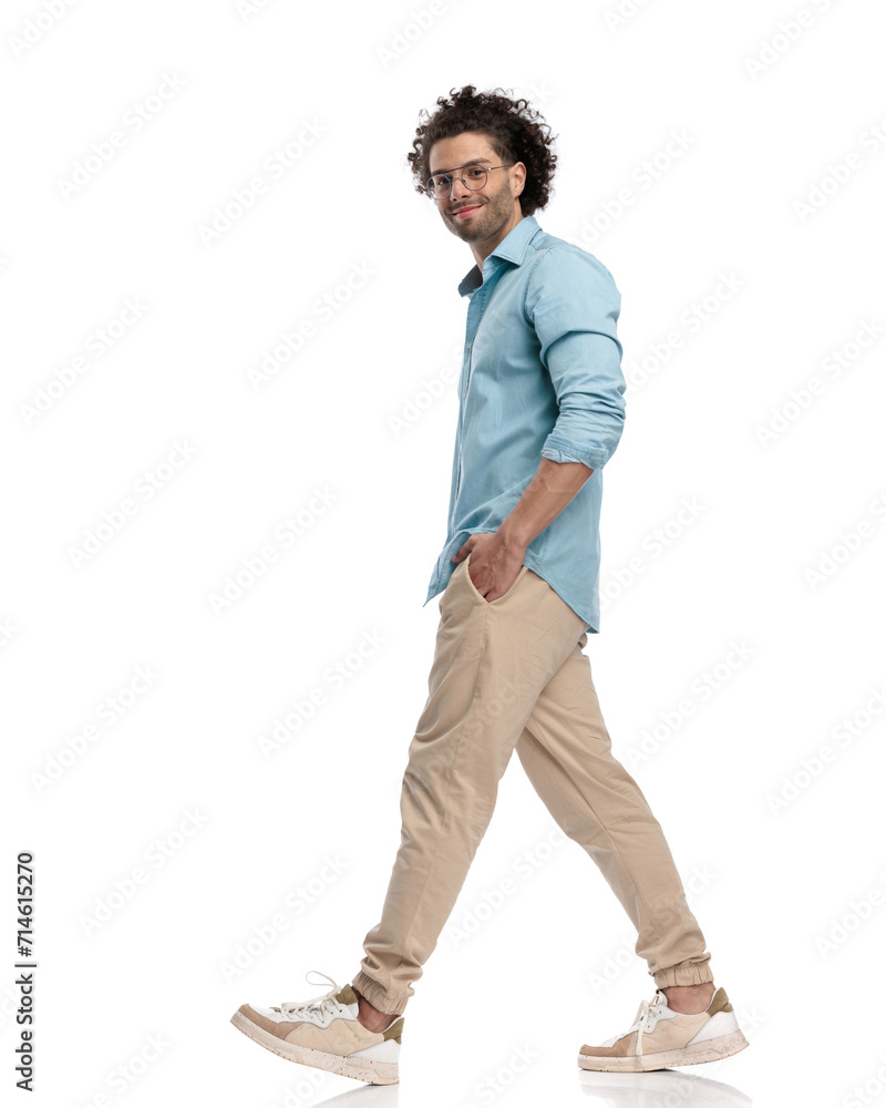 side view of relaxed casual man walking while holding pockets side view of relaxed casual man walking while holding pockets