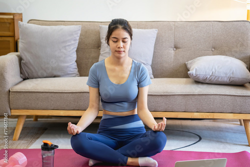 Healthy young woman doing breathing exercises at home, beautiful woman meditating at home with eyes closed, practicing yoga, doing pranayama techniques Mindfulness meditation concept