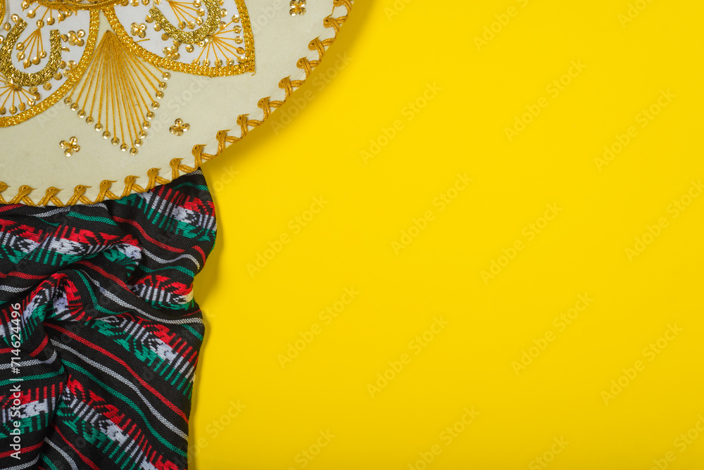 Obraz premium Mariachi hat and serape on yellow background. Mexican independence concept. Cinco de mayo background.
