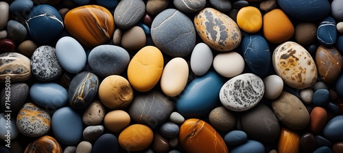 Brightly colored beach pebbles close up of smooth textures and vibrant hues in radiant sunlight.