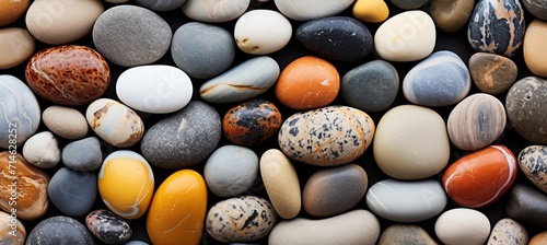 Vibrant beach pebbles with smooth textures under radiant sunlight, showcasing their colorful hues.