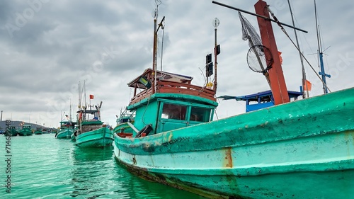 Colorful fishing boats moored in calm water under a cloudy sky  showcasing a traditional maritime setting