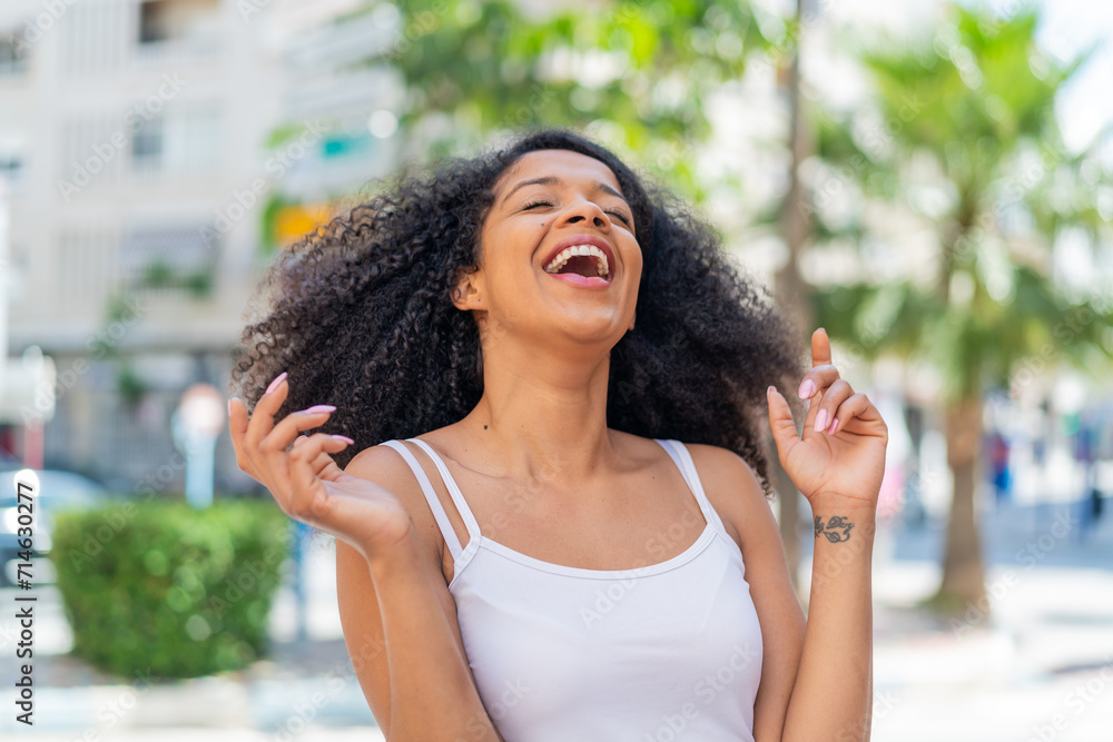 Young African American woman at outdoors smiling a lot