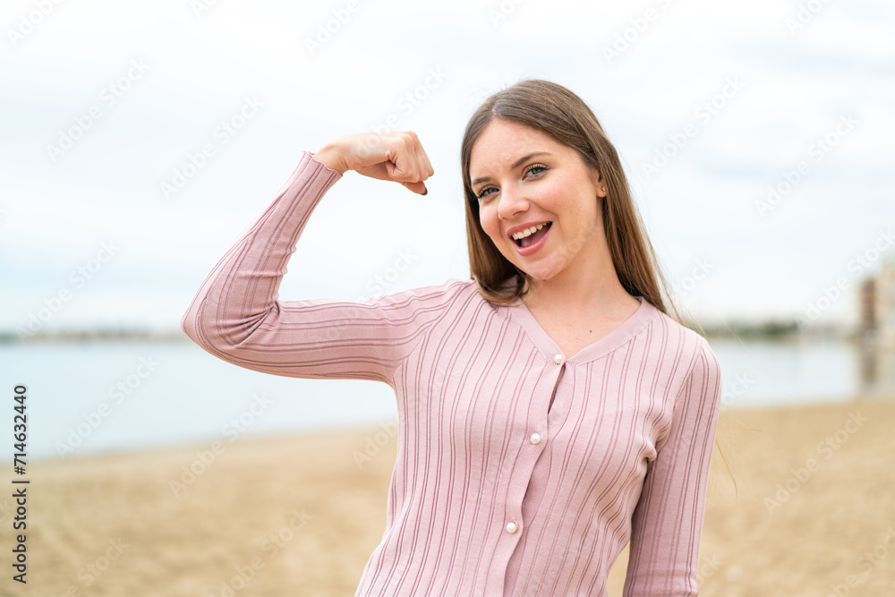 Young pretty blonde woman doing strong gesture