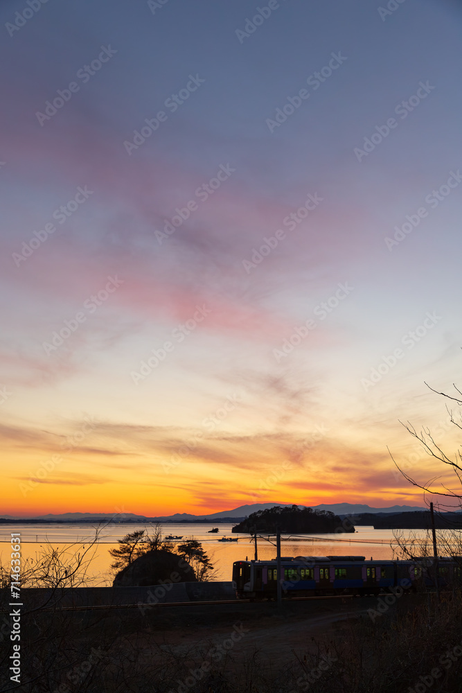 Fototapeta premium 夕暮れの松島を走る電車