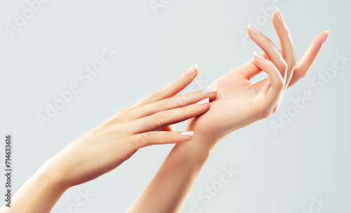 Hand skin care. Closeup of beautiful woman hands with  light manicure on nails . Cream for hands and treatment.
