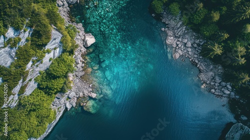  an aerial view of a body of water with rocks and trees around it, surrounded by rocks and greenery, and surrounded by blue water surrounded by rocks and greenery.