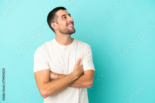 Young handsome caucasian man isolated on blue background happy and smiling