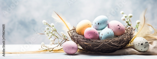 Nests with quail Easter eggs on a soft blue wooden background.